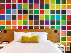 a bedroom with a bed and a colorful wall at ibis Styles Brisbane Elizabeth Street in Brisbane