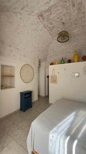 a bedroom with a white bed and a fireplace at La Mia Lamia in Cisternino +22 photos