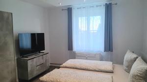 ヨハンジョルゲンシュタットにあるFerienwohnung Bergluftの薄型テレビとソファのあるリビングルーム