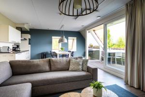 a living room with a couch and a dining room at Residence Terschelling Wellness Waddenresort in Midsland