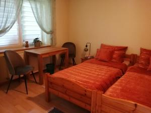 a bedroom with two beds and a desk and a table at Bärenhof Langenbernsdorf in Langenbernsdorf