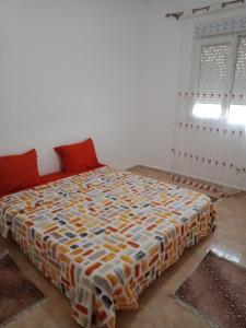 a bedroom with a bed with a colorful comforter at حمودي شقق مجهزة للكراء مرحبا بالجميع in Skikda