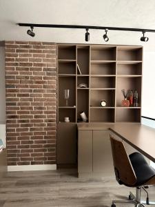 una oficina con una pared de ladrillos y un escritorio y una silla en The Brick Studio, en Colentina