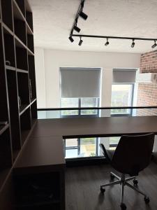 una oficina con un escritorio grande y una silla en The Brick Studio, en Colentina