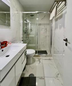 Un baño blanco con ducha y WC. en Almada Downtown 201, en Oporto