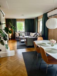 a living room with a couch and a table at Hus med stor trädgård i lugn miljö nära havet in Bunkeflostrand