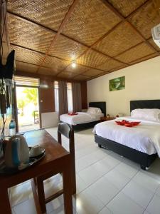 a hotel room with two beds and a table and a table sidx sidx at Siuri Cottages & Restaurant in Tokaimbu
