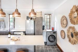 a kitchen with a refrigerator and a washing machine at Avemore Orchard Apartment - with full Backup power in Stellenbosch