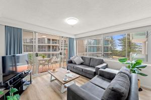 a living room with a couch and a tv at Pacific Regis Beachfront Holiday Apartments in Gold Coast