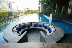 a swimming pool with a bench in front of a building at Hakuna Stays in Makassar