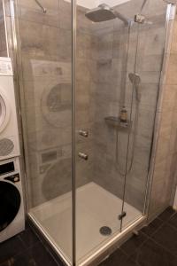 een douche met een glazen deur in een badkamer bij JobelHome Castle District Apartments in Boedapest +27 foto's