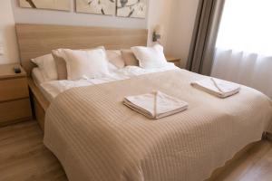 een slaapkamer met een groot bed met twee handdoeken erop bij JobelHome Castle District Apartments in Boedapest