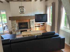 a living room with a couch and a fireplace at Cozy family home in Champagne-en-Ardenne 8p in Rubigny