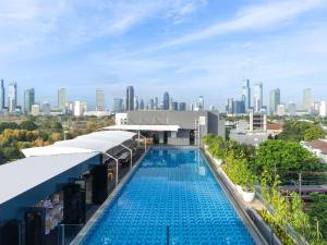 a swimming pool with a city skyline in the background at Mercure Jakarta Cikini in Jakarta +54 photos