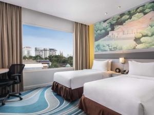 Postel nebo postele na pokoji v ubytování Mercure Jakarta Cikini