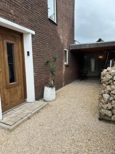 a brick building with a door and a potted plant at Studio Cabana Oegstgeest in Oegstgeest