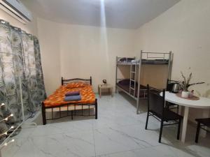 a room with a bed and a table and a table and chairs at Cozy Corner 2024 in Abu Dhabi