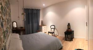 a bedroom with a bed and a dresser and a chair at Chambre 2 personnes in Saint-André-de-Sangonis +1 photo