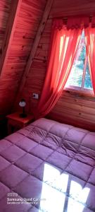 a bedroom with a bed and a window at Cabaña Galuel in Aluminé