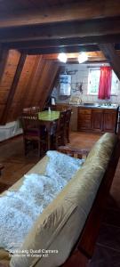 a large bed in a room with a table and chairs at Cabaña Galuel in Aluminé