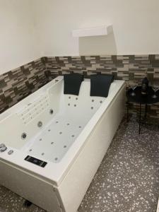 a large white bath tub in a room with a table at Studio avec jacuzzi à Adjarra in Adjarra +21 photos