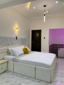 a bedroom with a large white bed with yellow pillows at Studio avec jacuzzi à Adjarra in Adjarra