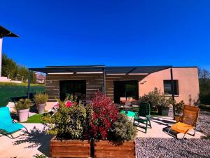 eine Terrasse mit Stühlen und Pflanzen sowie ein Gebäude in der Unterkunft Gîte L'escapade dauphinoise 2 chambres parking privé in Beaucroissant