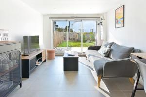 a living room with a couch and a tv at Piriac Norven Appartement maison 6p 500m plage in Piriac-sur-Mer
