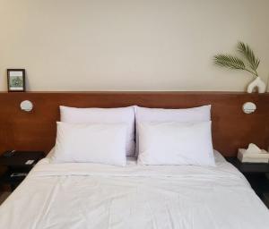 a bed with white pillows and a wooden headboard at Jeonju Hotel Book and Type in Jeonju