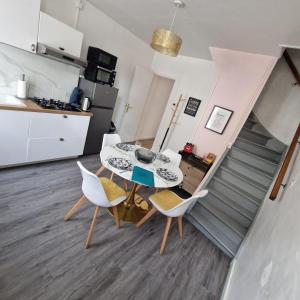 a kitchen and a dining room with a table and chairs at La Belle Armentières, maison triplex cosy proche de Lille in Armentières
