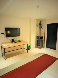 Una sala de estar con una mesa y un televisor. en Hotel Soni Mansion Pratunam, en Bangkok 53 fotos más