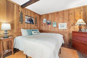 a bedroom with a bed and a wooden wall at Adventure Basecamp! Cabin near all Attractions! in Beaver Dams