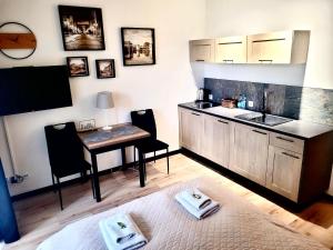 a kitchen with a table and a sink and a desk at Apartament przy Starówce z tarasem in Elblag