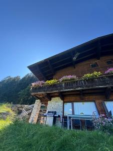 Una casa con flores al costado. en Ferienwohnung Alpenlodge 52, en Aschau