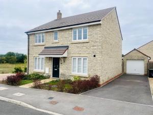 ein großes Backsteinhaus mit Parkplatz in der Unterkunft Stunning Modern Four Bed Home Near Witney & Oxford in Oxford