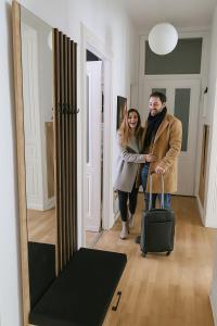 un homme et une femme debout dans une pièce avec une valise dans l'établissement Beletage Cologne, à Cologne