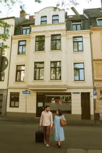 un homme et une femme marchant devant un bâtiment dans l'établissement Beletage Cologne, à Cologne