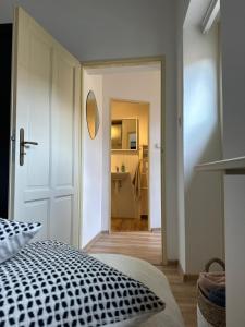 a bedroom with a black and white bed and a bathroom at Apartmán ve dvoře in Žatec