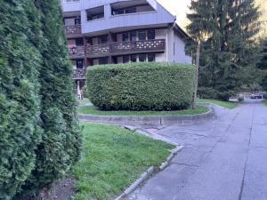 a building with a hedge in front of a street at Nouveau Refuge de l aiguille in Chamonix-Mont-Blanc