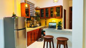 a kitchen with a refrigerator and two bar stools at Paradise Walk Stay in Nikawatawana