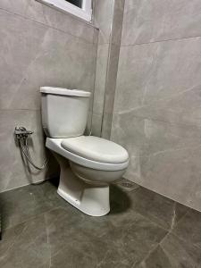 a bathroom with a white toilet in a room at Villa Garden in Prishtinë