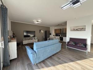 a living room with a blue couch and a tv at Exceptionnel appartement avec vue mer in Vendres-Plage