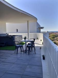 a patio with chairs and a table on a balcony at Exceptionnel appartement avec vue mer in Vendres-Plage