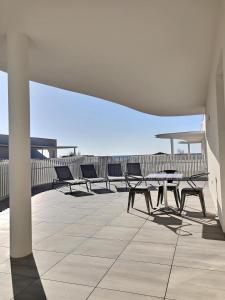 a group of chairs and tables on a balcony at Exceptionnel appartement avec vue mer in Vendres-Plage