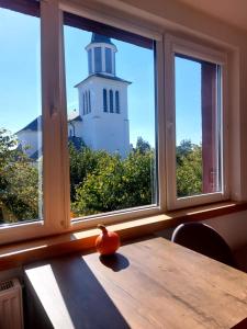 an orange sitting on a table in front of a window with a lighthouse at Apartament Pod Lipami in Hajnówka