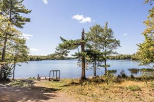a picnic table on the shore of a lake at Sunken Escapes Cabin 7 in New Minas