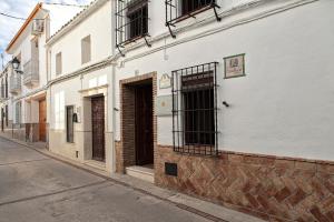 un edificio bianco con una porta su una strada di Casa Rural El Membrillo a Carcabuey