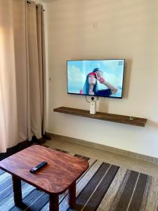 a living room with a flat screen tv on a wall at Nautical Nest Apartments in Malindi