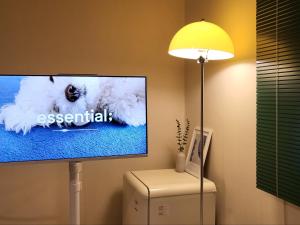 a flat screen tv sitting on a stand next to a lamp at Jeonju Hotel Book and Type in Jeonju