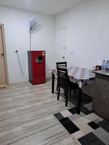cocina con mesa, sillas y nevera roja en Nav's B&B, en Nadi 5 fotos más